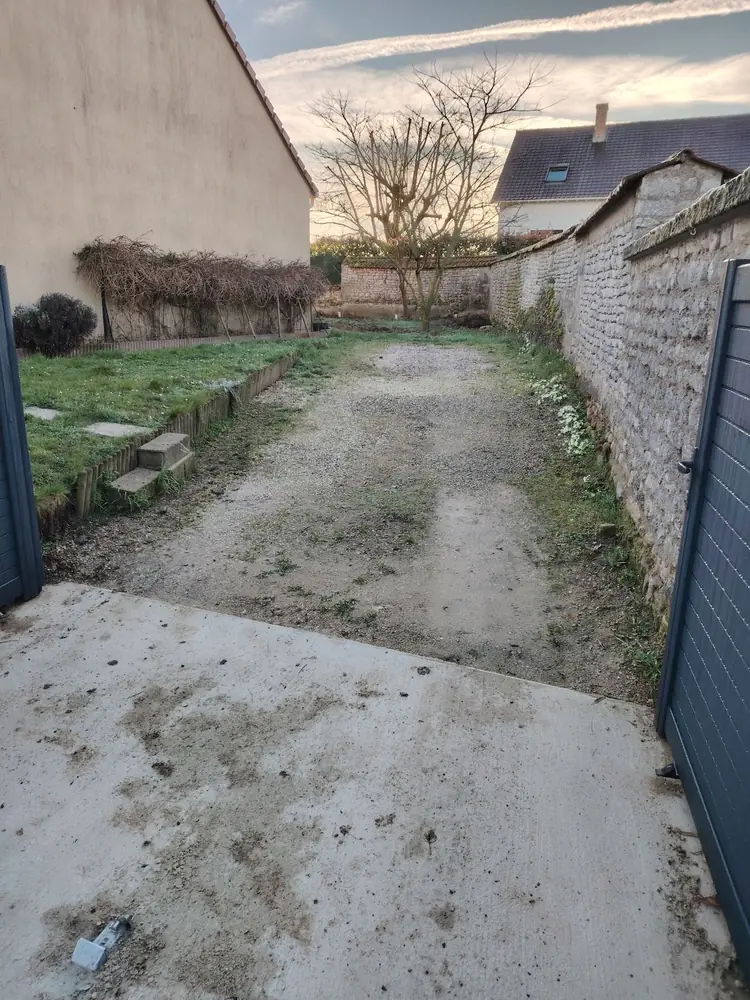 Bande de terre et d’herbe entre la maison et le mur en pierre, avant les travaux