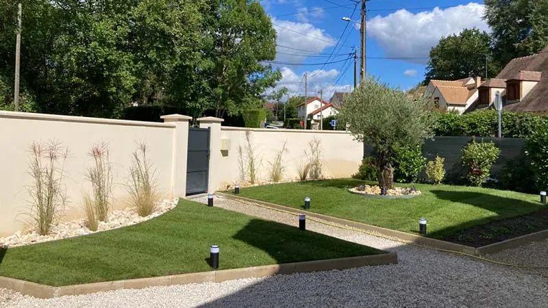 Entrée de maison après aménagement : gazon, massifs et bordures