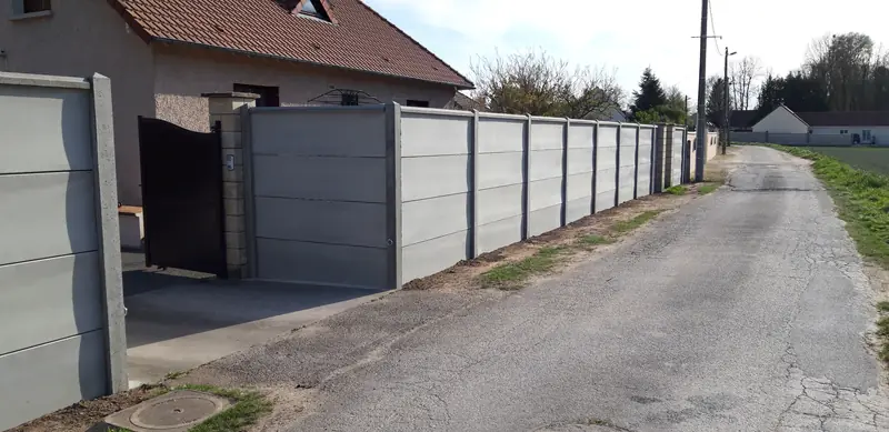 Clôture en plaques de béton le long de la rue