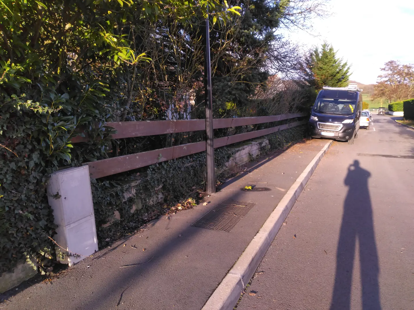 Ancienne clôture en bois abîmée le long du trottoir, avant travaux