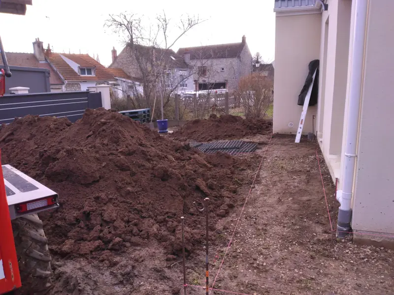 Tas de terre végétale le long de la maison