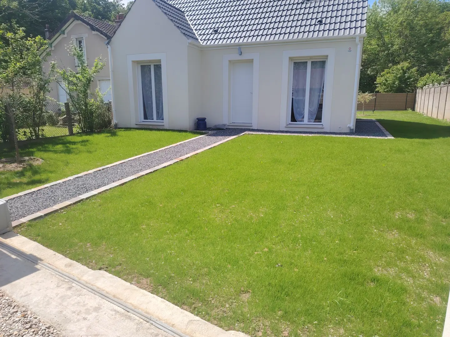 Gazon levé et allée devant la maison neuve