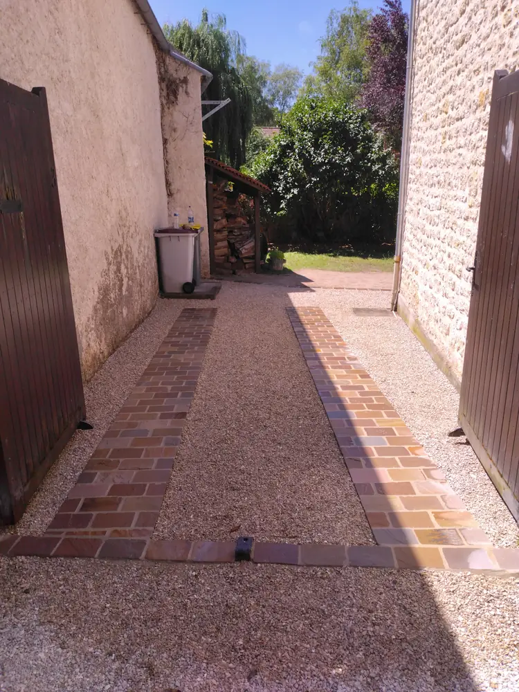 Bande de roulement en pavés Kandla multicolores et gravier stabilisé entre deux murs