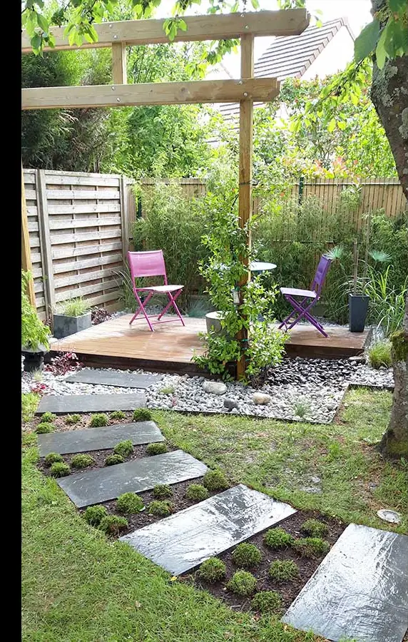 Pas japonais dans le gazon menant à un coin détente sous pergola